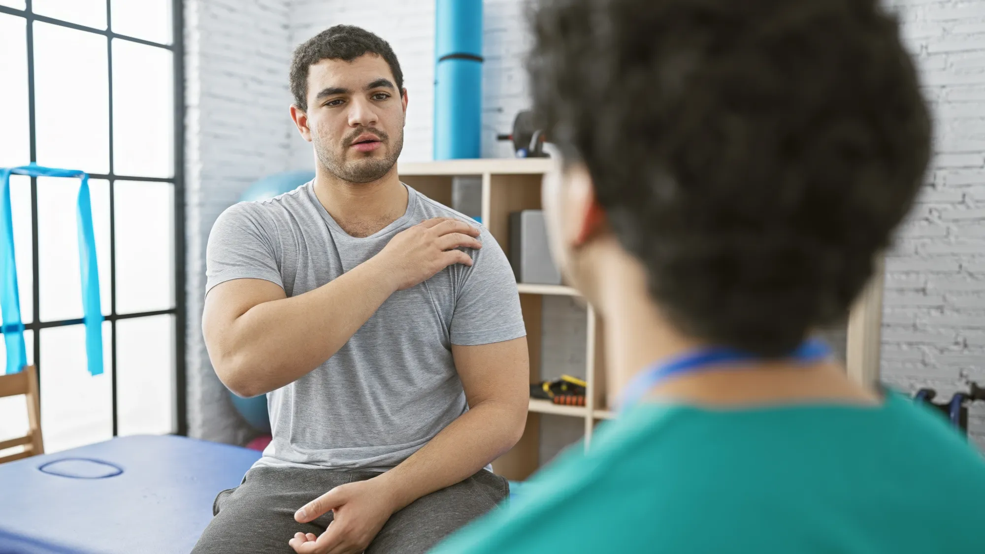 Patient and doctor discussing the differences between a rotator cuff tear vs strain.