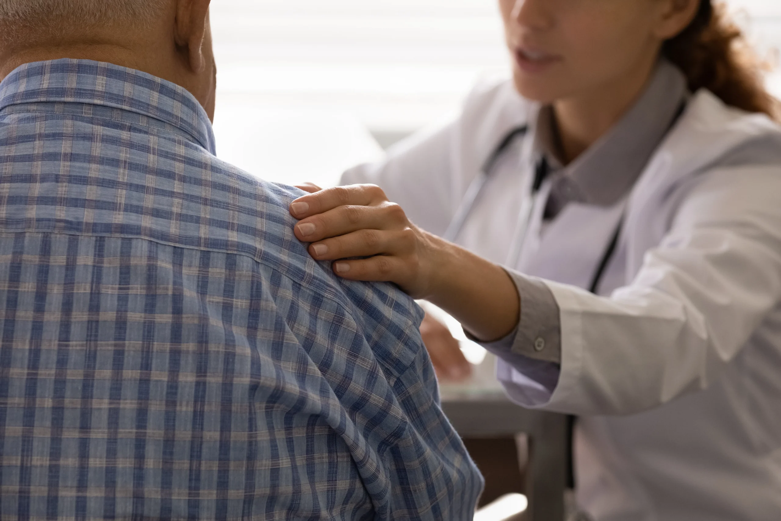 A doctor looking at someone's shoulder to see if they need a PRP injection.